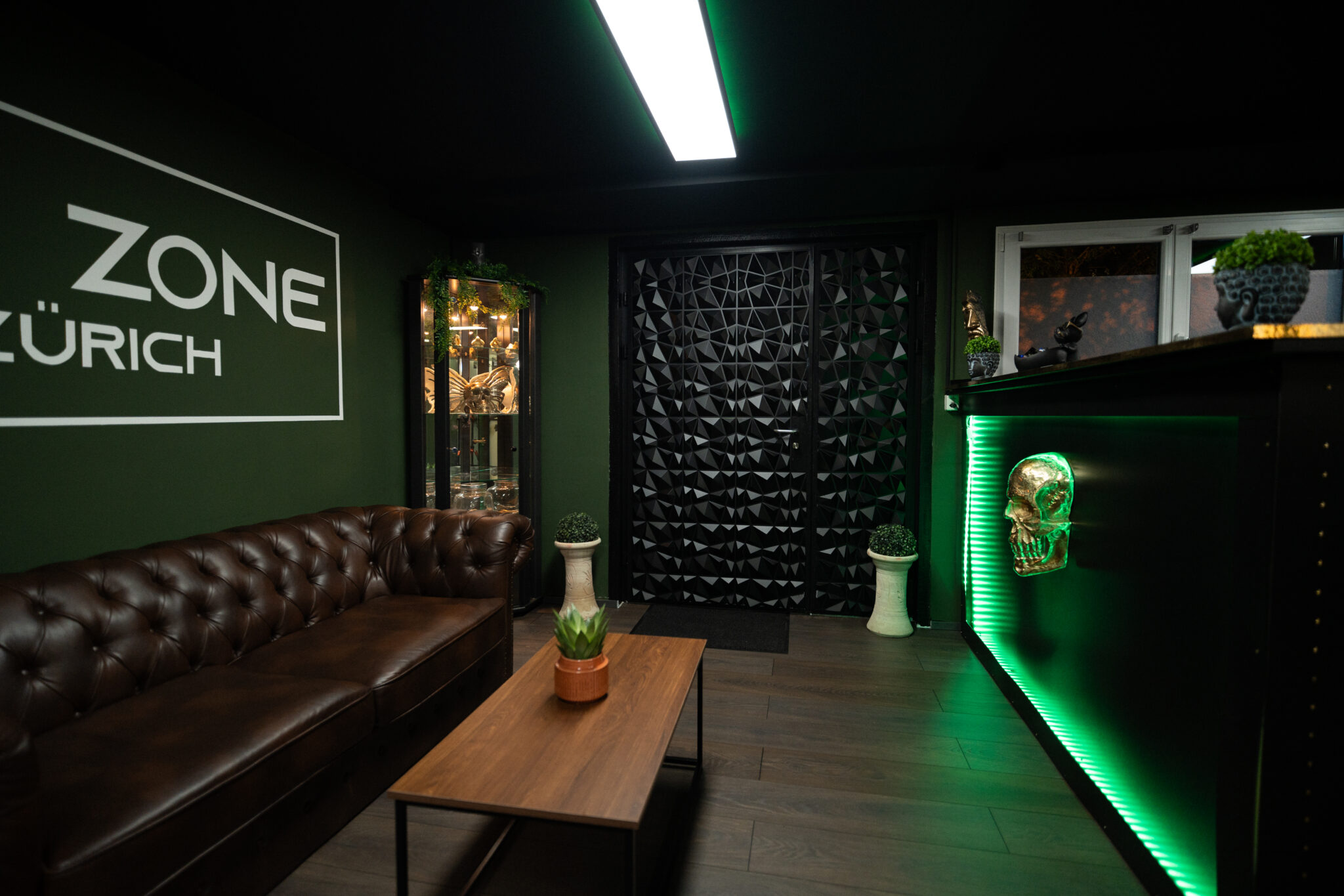 Lounge mit Chesterfield-Sofa und Wandschriftzug INK ZONE ZÜRICH